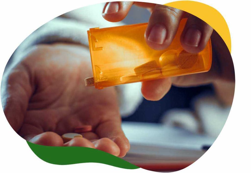 A person’s hand pouring the medicine out of the bottle on her right palm