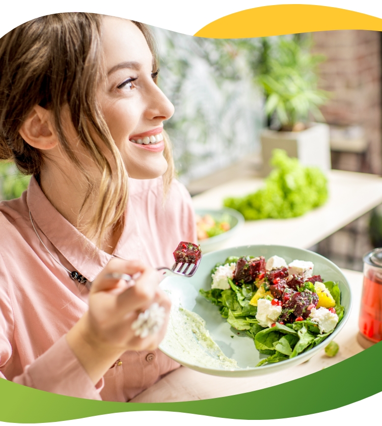 A young woman enjoying her salad and looking out the window